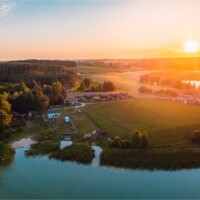 Widok z lotu ptaka na jezioro, domki i linię brzegową z plażą Widok z lotu ptaka na jezioro, domki i linię brzegową z plażą